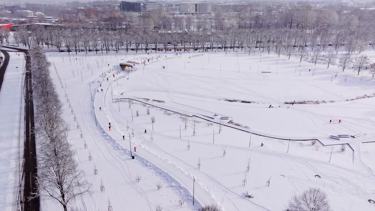 Snow Covered Victory Park In Riga Latvia Seen From High Drone With Urban Skyline