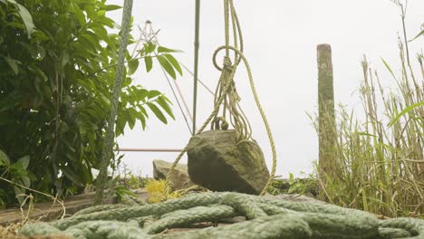 Method-of-fishing-,-A-Chinese--net-stone-used-for-fishing-in-backwaters,-A-stone-hanging-from-a-Chinese-net-,