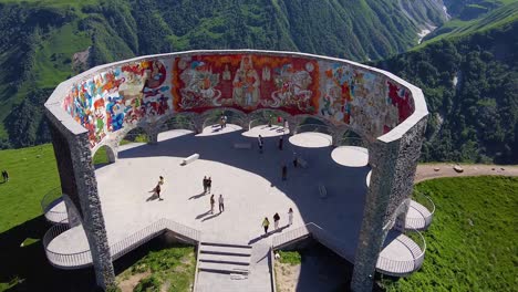 Cinematic-drone-shot-showing-ancient-monument-in-Georgia-in-front-of-beautiful-mountains