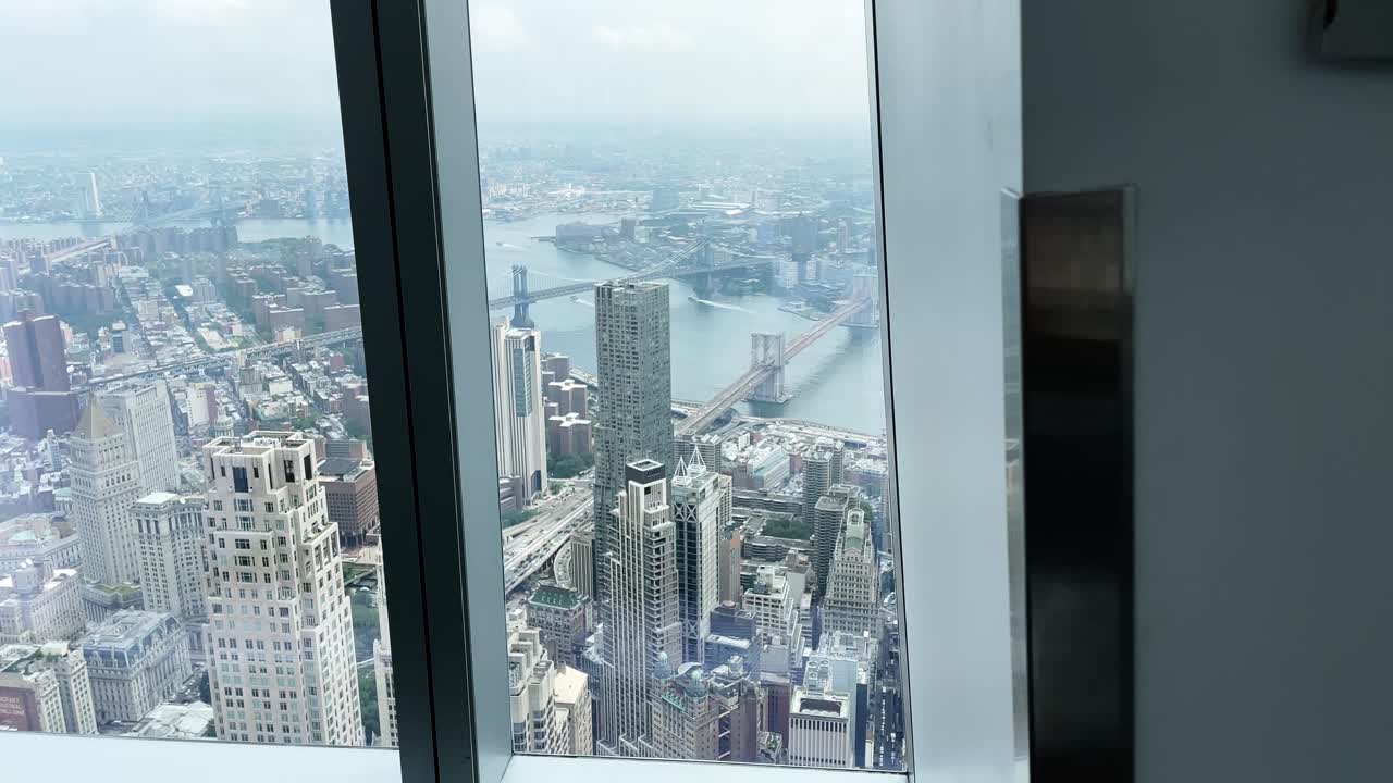 Catching a glimpse along the window from One World Observatory in New York Manhattan overlooking the Brooklyn Bridge and the Manhattan Bridge