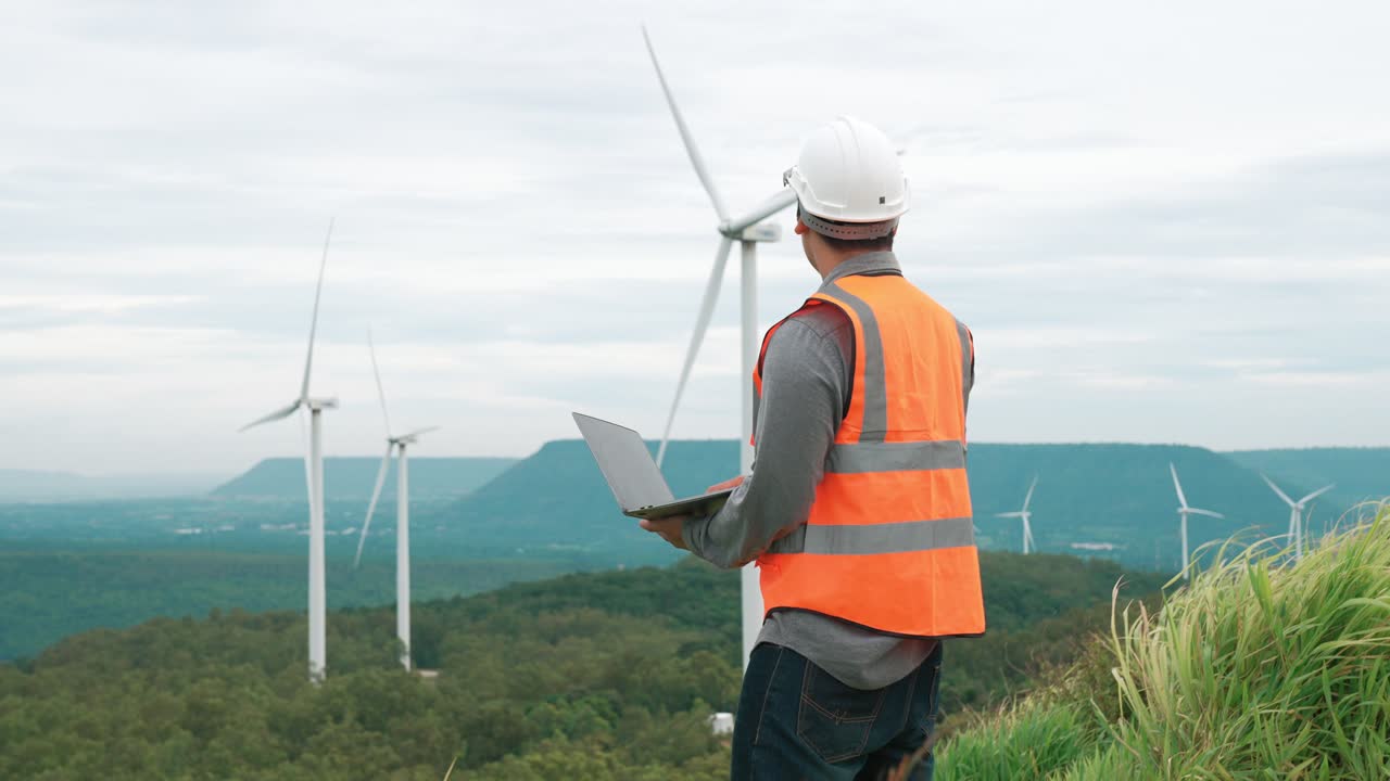 concepto progresivo de ingeniero trabajando en el parque eólico en la cima de la montaña.