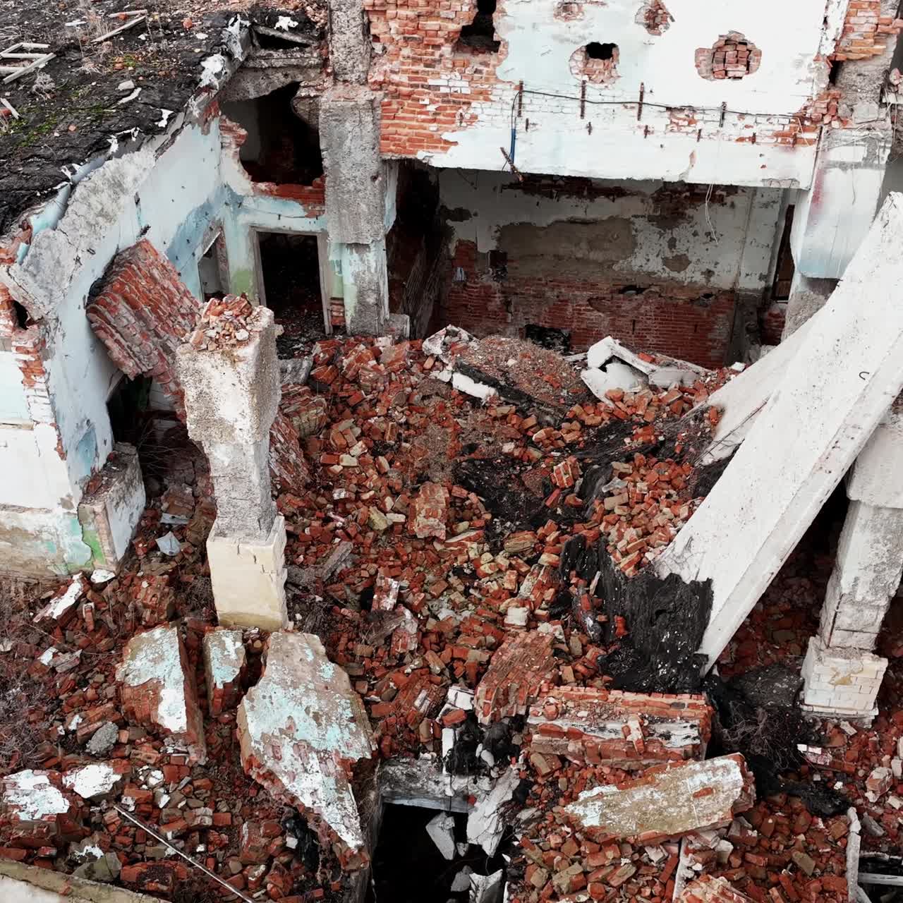 Ruins left from the building resulting from an earthquake. A huge pile of bricks and concrete among the wall leftovers. View from above
