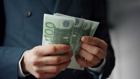 Man-counting-hundreds-euro-indoors-close-up.-Hands-calculating-european-bills