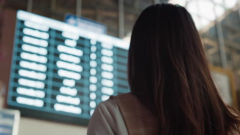 mujer comprobando el horario de vuelo en el aeropuerto