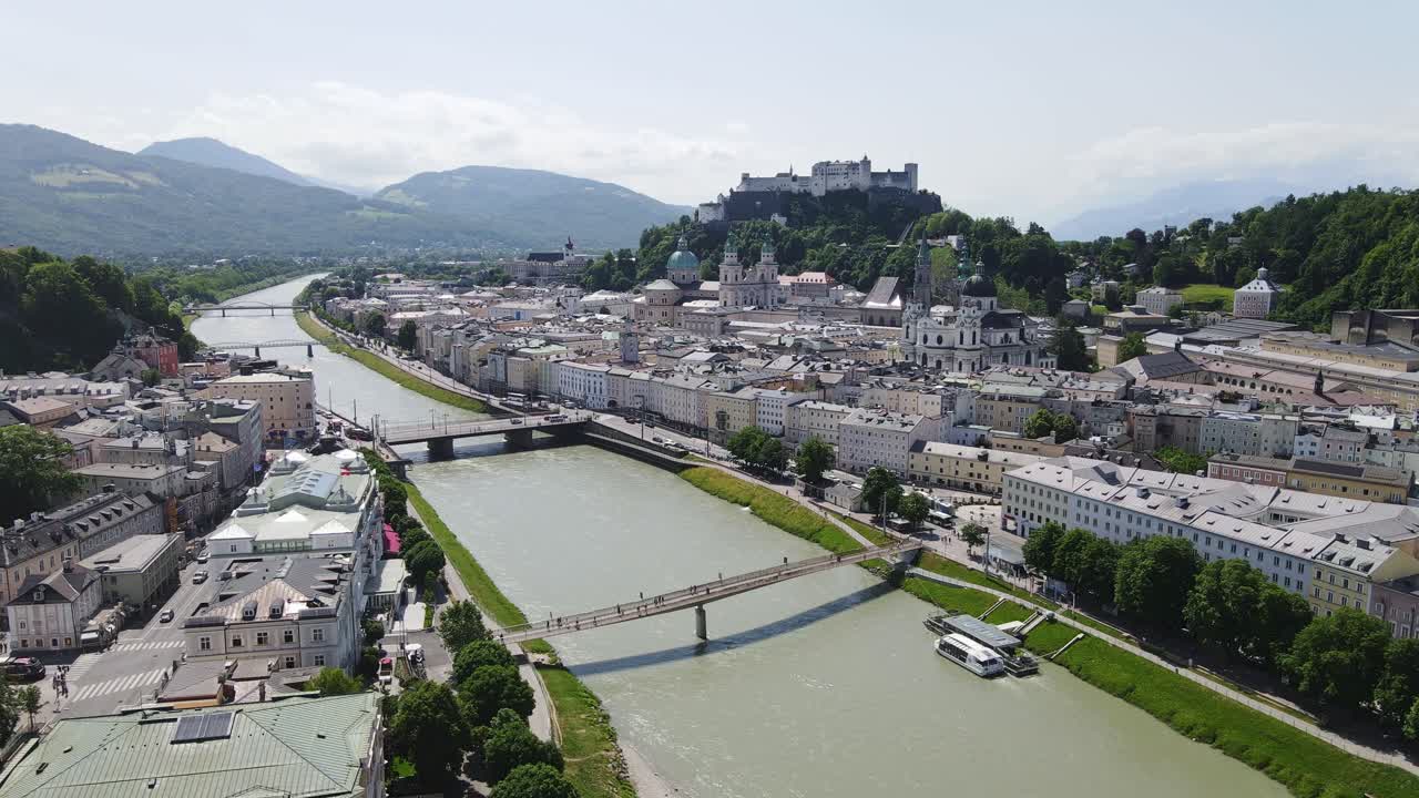 Panoramic view of Salzburg's river, framed by mountains and historic buildings