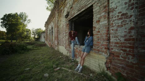 two friends enjoying time outdoors, near an abandoned building.