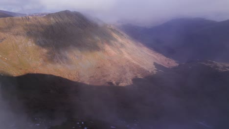 drone disparó volando hacia adelante a través de las nubes para revelar el paisaje debajo, helvellyn, distrito de los lagos, cumbria, reino unido