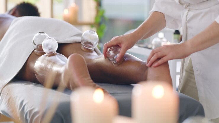Mand på spa, der modtager cupping terapeutisk benmassage