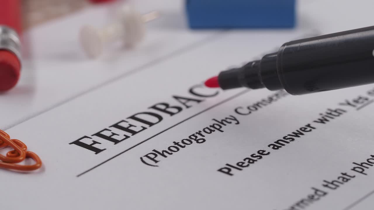 Underlining 'Feedback' on a Survey Document with a Red Marker