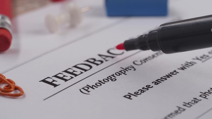 Underlining 'Feedback' on a Survey Document with a Red Marker