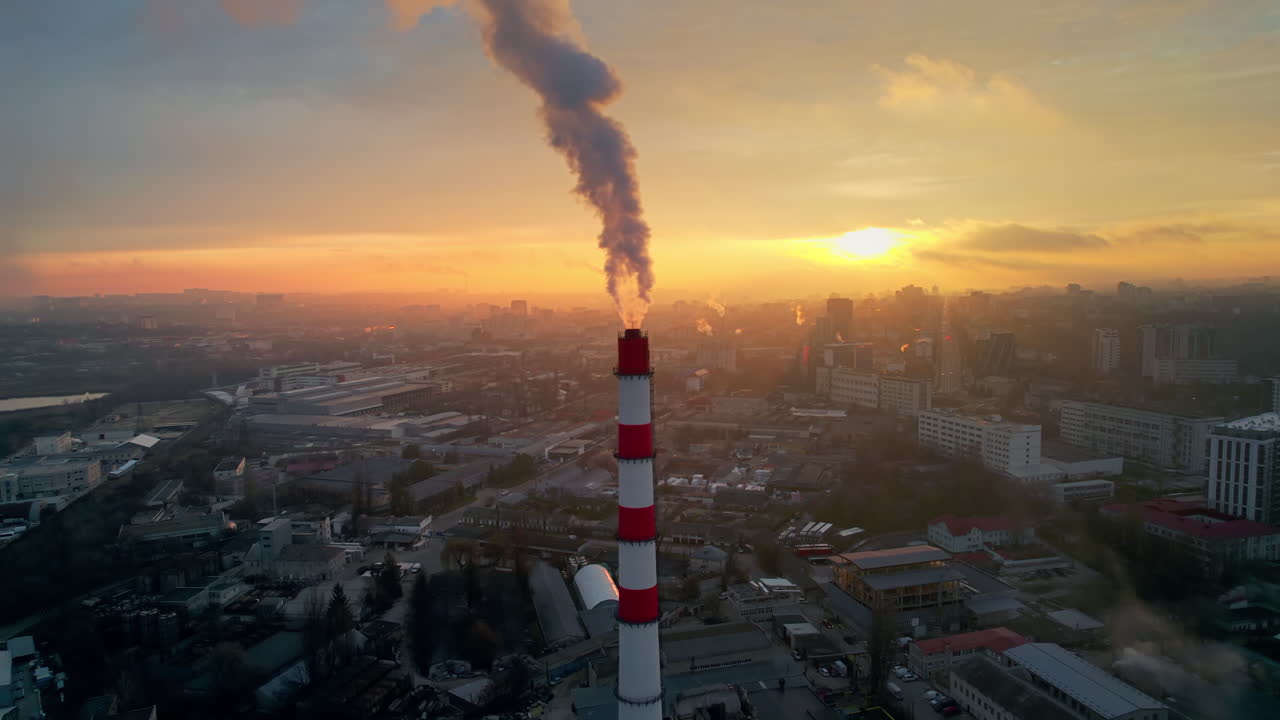 Aerial drone view of thermal power plant in Chisinau at sunrise, Moldova. View of pipe with felling steam, cityscape