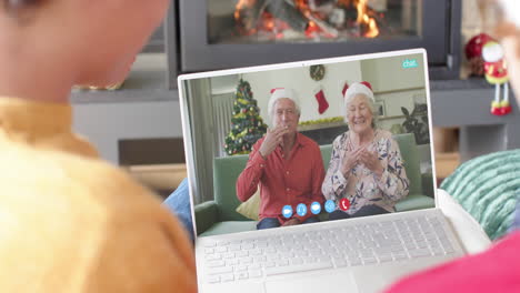 Happy-caucasian-couple-and-senior-parents-having-christmas-laptop-video-call,-slow-motion