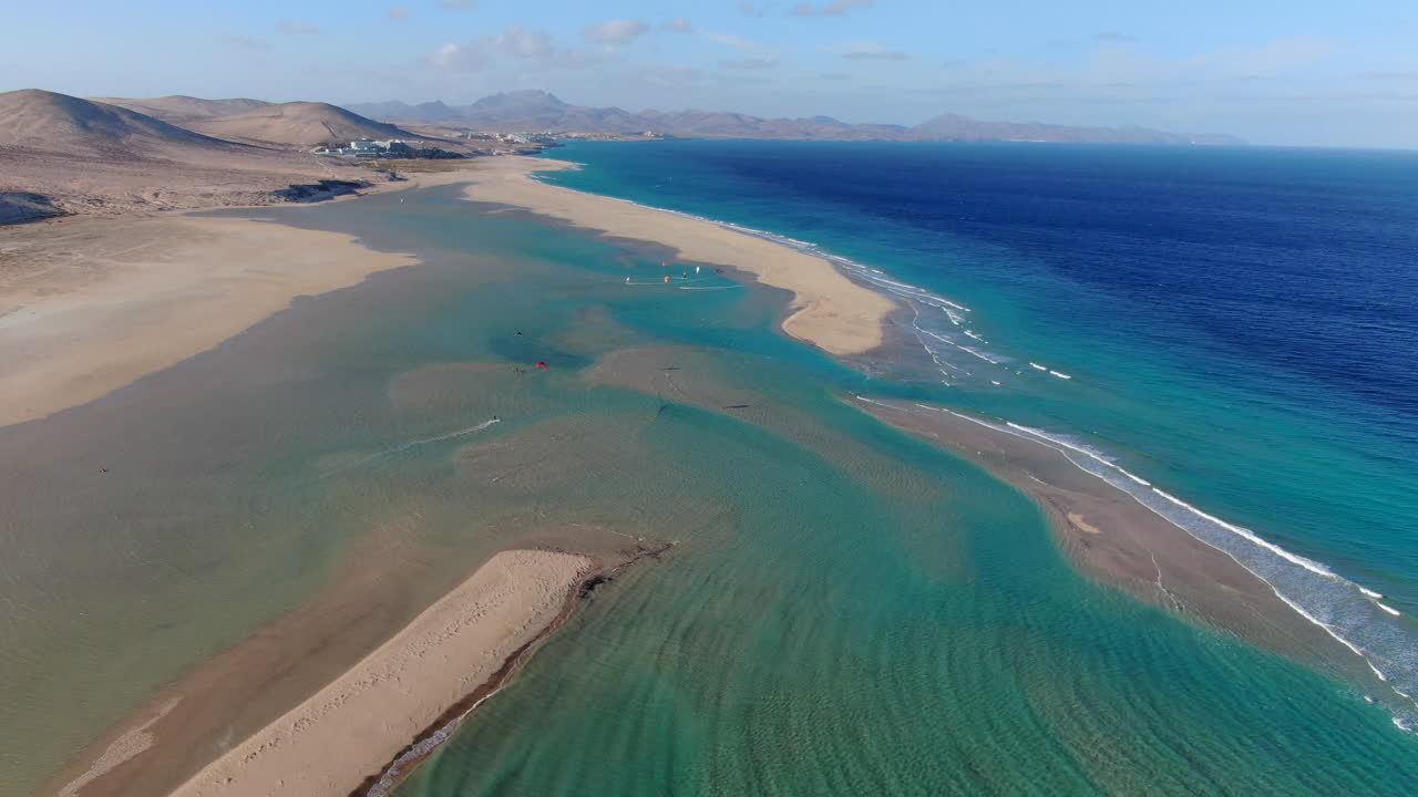 la playa de la barca, fuerteventura: vista aérea en un círculo sobre la hermosa playa, personas practicando windsurf y kitesurf