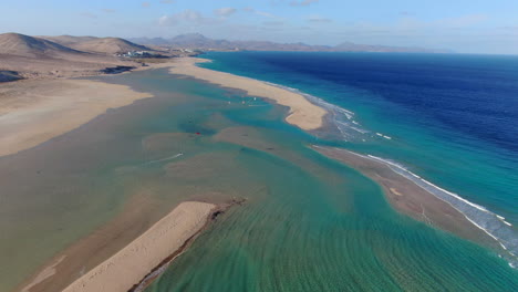 la playa de la barca, fuerteventura: vista aérea en un círculo sobre la hermosa playa, personas practicando windsurf y kitesurf