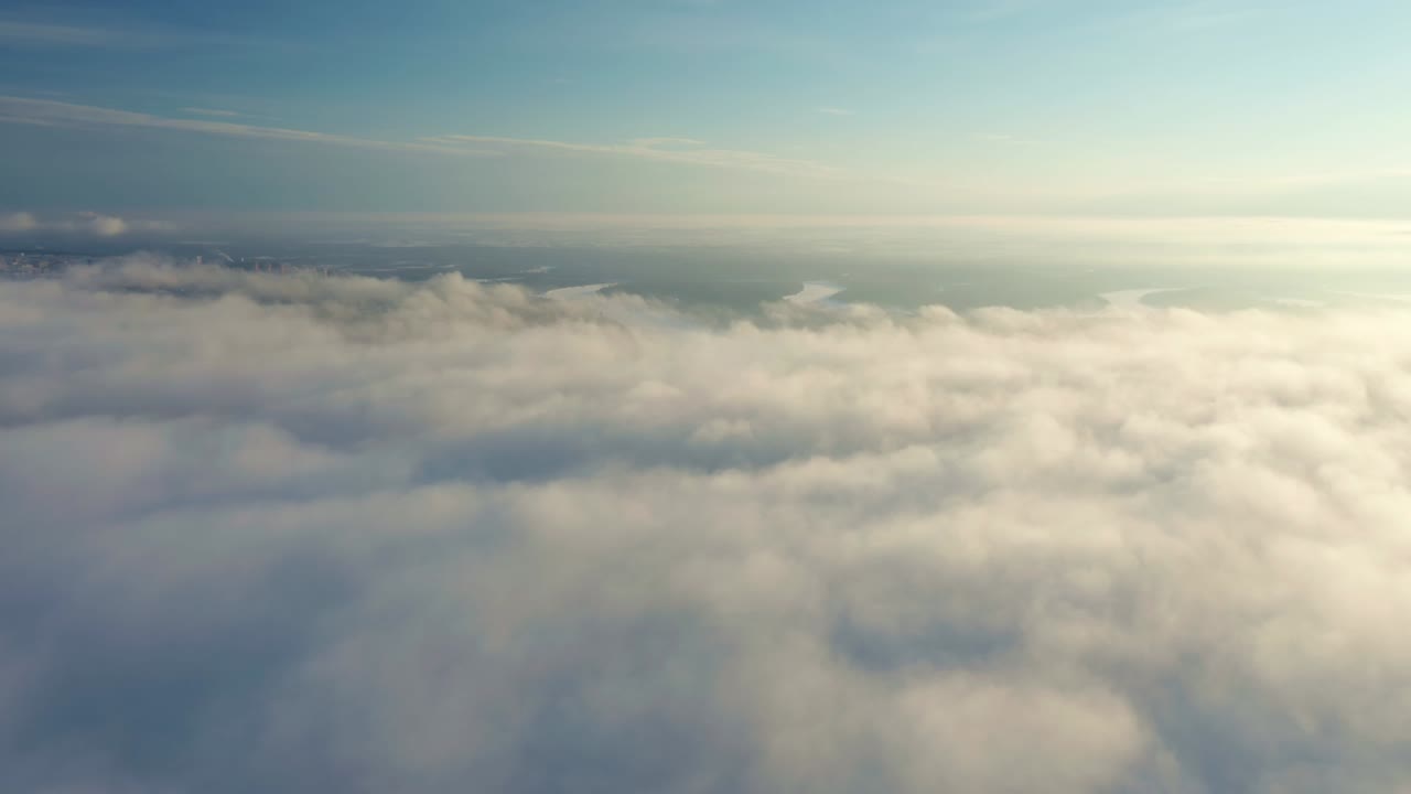 Cumulus clouds fill the sky with a dense layer. Footage shows a game of light and shadow at sunset. Green fields is below.