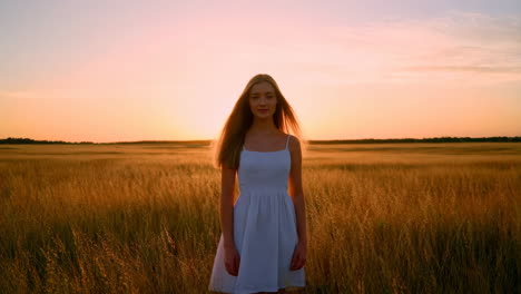 woman in white dress in wheat field at sunset