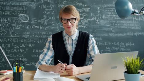 teacher working at a desk in a classroom