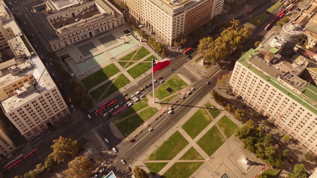 Aerial view of the Bandera Bicentenario, a monumental Chilean flag waving proudly along a busy avenue in de Chile, along with city traffic.