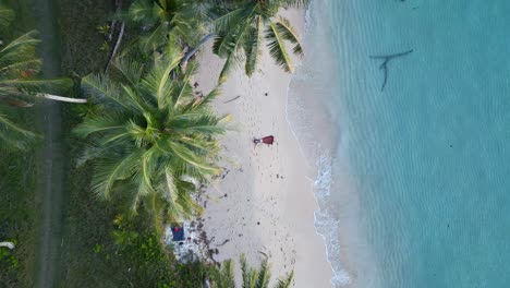 Woman-lying-with-long-skirt-on-dream-beach-under-palm-tree