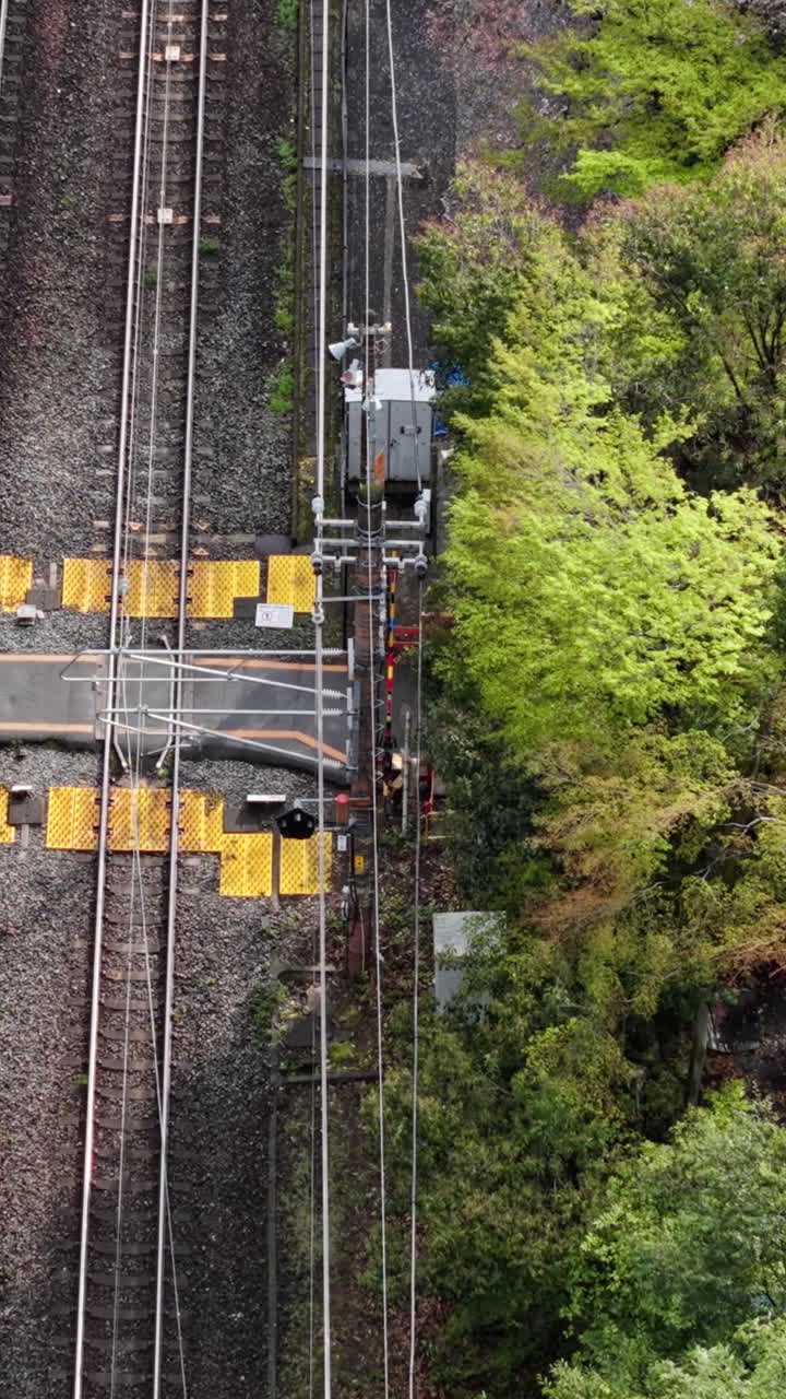 Aerial drone view of a train moving through the Arashiyama train station, Kyoto, Japan in daylight