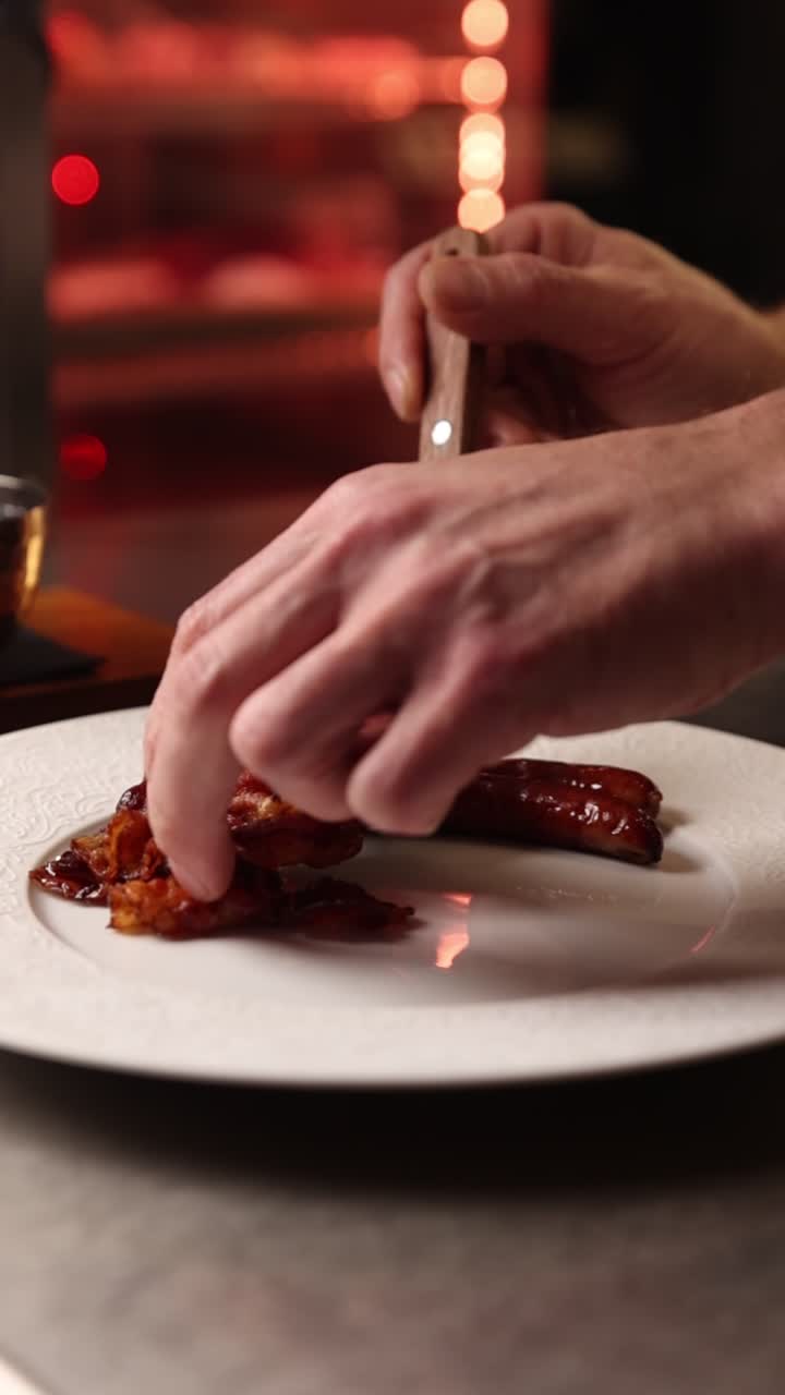 Chef's Hands Plating Sausage and Caramelized Onions on a White Dish