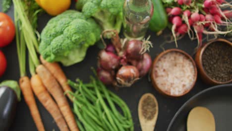 video de verduras frescas, sartén y especias sobre un fondo gris