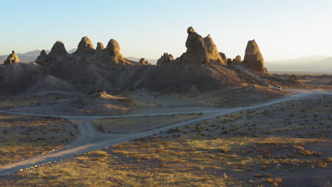 Vista-Aérea-Rápida-Volando-Hacia-Los-Pináculos-De-Trona-En-El-Desierto-De-Mojave-Durante-Un-Amanecer-Amarillo-Brillante