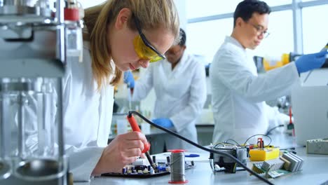 female scientist soldering circuit board 4k