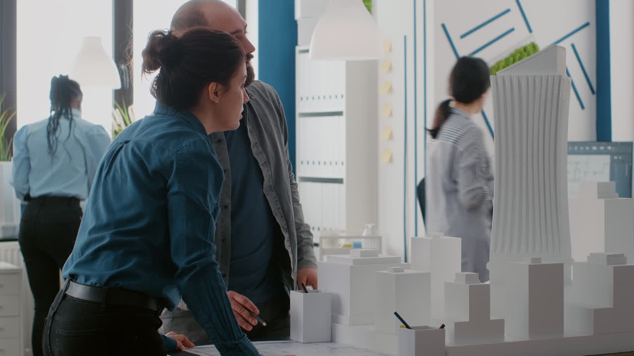 Architects Collaborating on Building Model and Blueprint