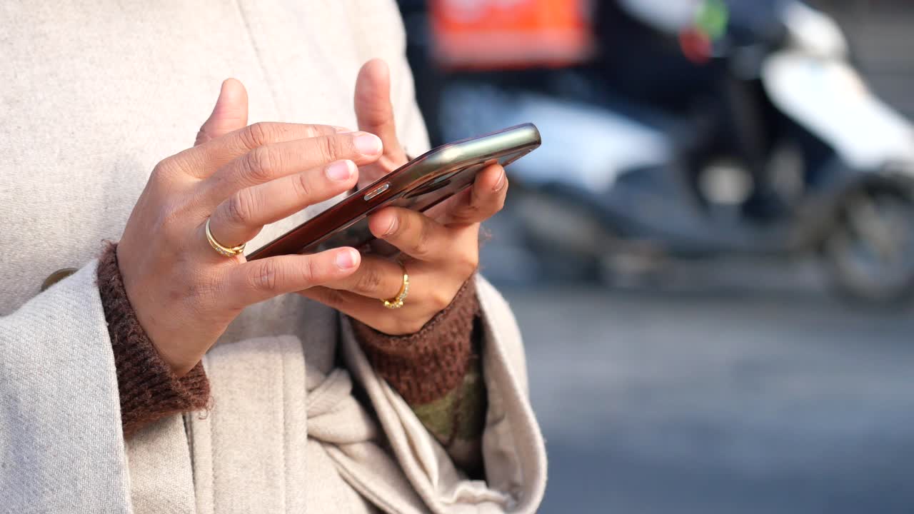 Person's Hands Typing on Smartphone Outdoors