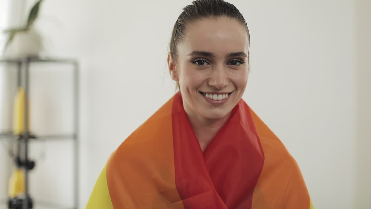 Woman smiling with LGBTQ rainbow flag