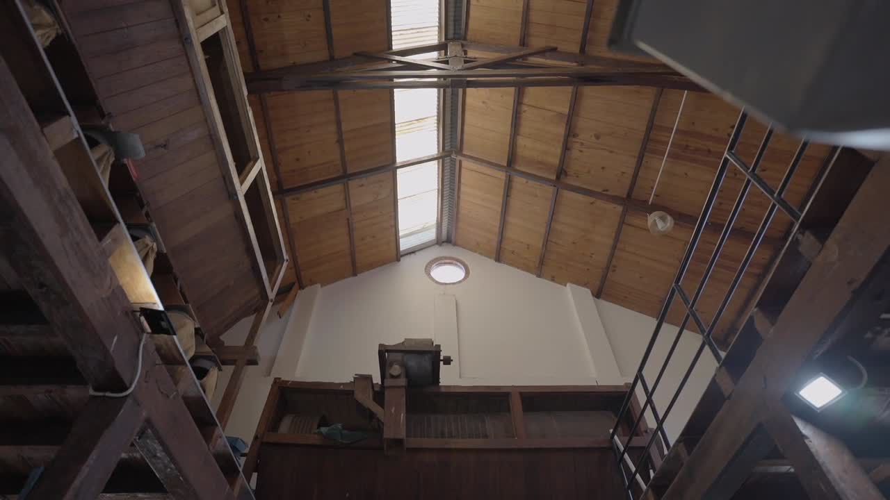 Interior view of an old yerba mate factory, capturing the bright, sunlit roof above.