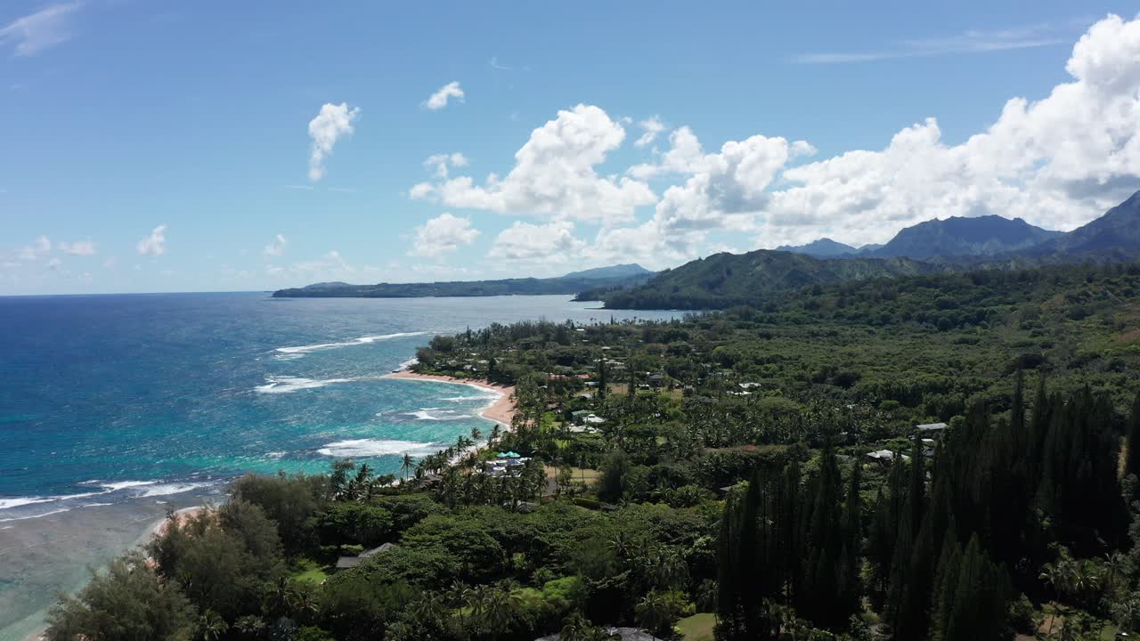 Wide aerial shot flying over the small Hawaiian village of Haena on the island of Kaua'i