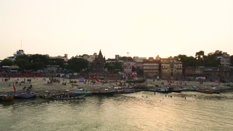 aerial drone shot of banaras, with the iconic ghats of the ganga river bathed in morning light.