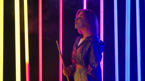 young woman smoking hookah under neon lights