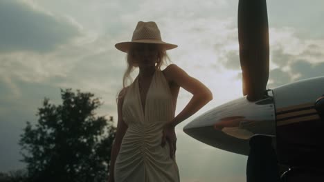 woman in a vintage dress by a vintage airplane
