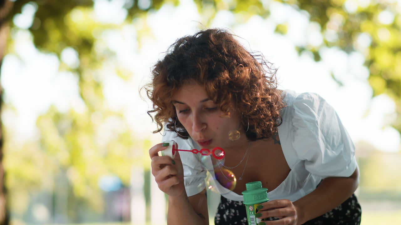 mujer soplando burbujas al aire libre