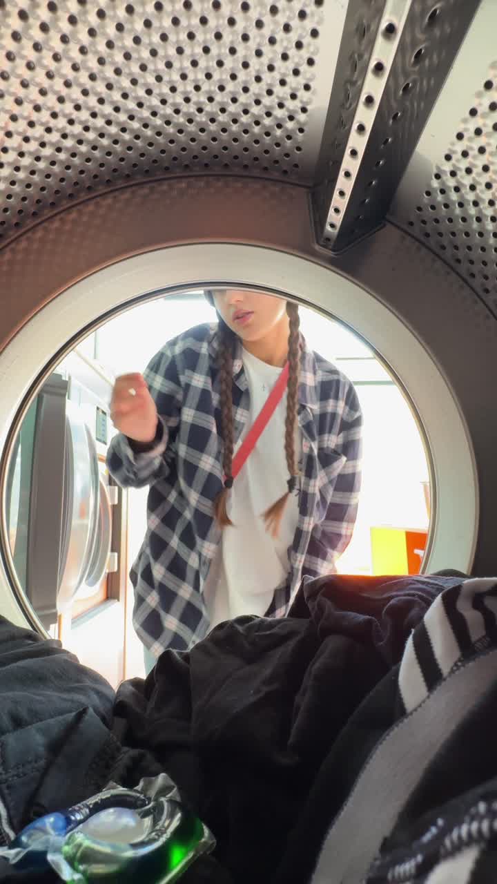 Person Loading Clothes into a Washing Machine