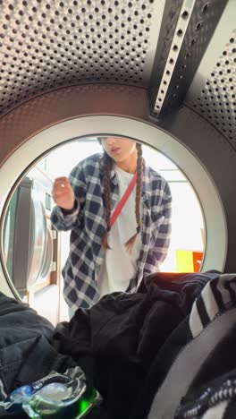 person loading clothes into a washing machine