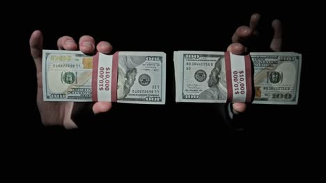 two stacks of 10000 american dollars bundles in male hands on black background