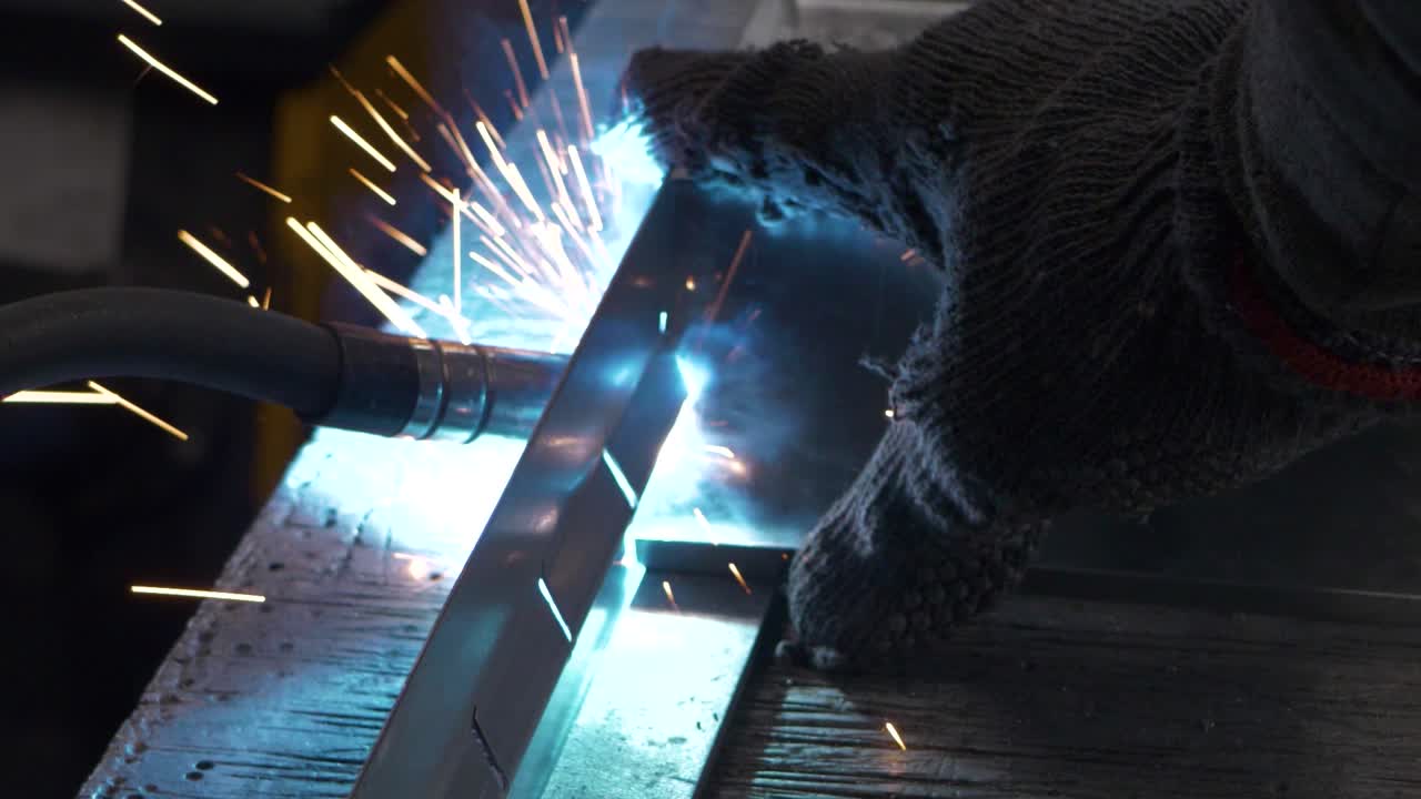 Welder works in metal construction - construction and processing of steel components