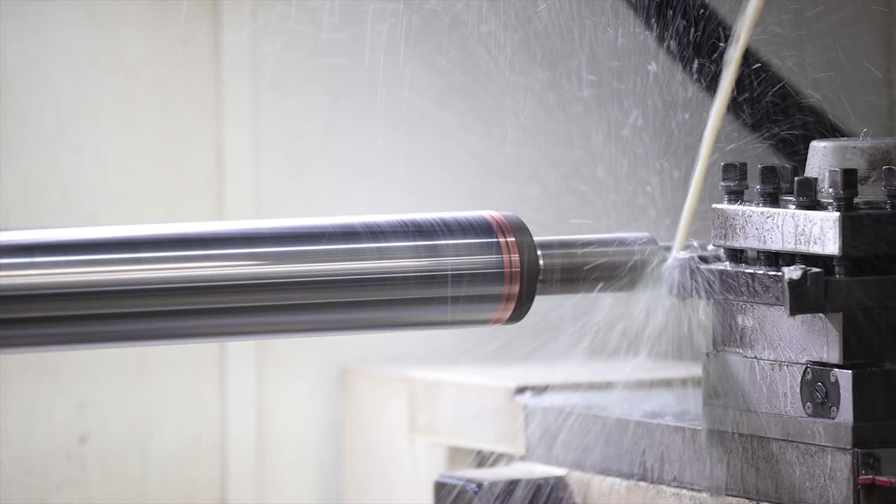 Processo intensivo di tornitura dei metalli su tornio CNC con spruzzo di liquido refrigerante per il controllo della temperatura.