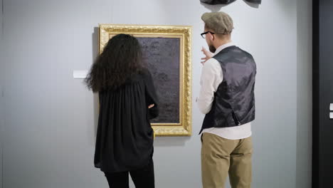 visitors viewing a painting in an art gallery