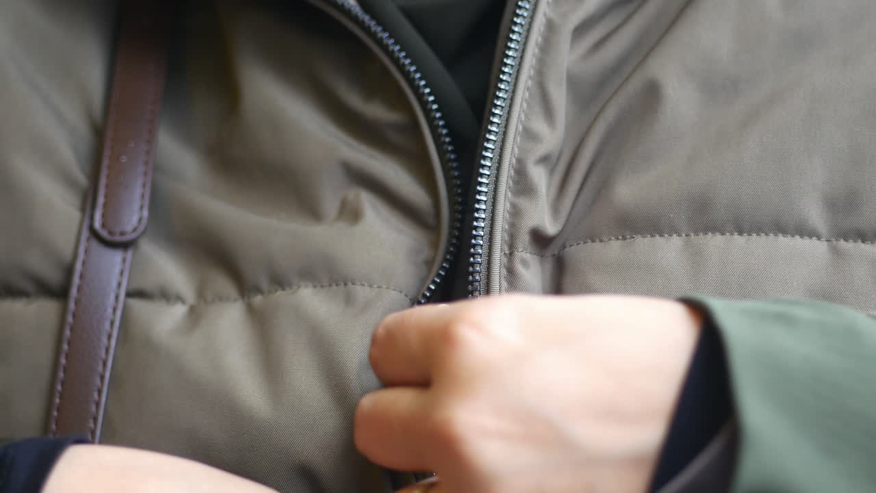Close-up of Hands Zipping Up a Jacket