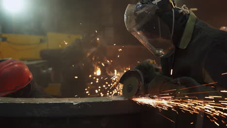 metalworkers grinding metal in a factory