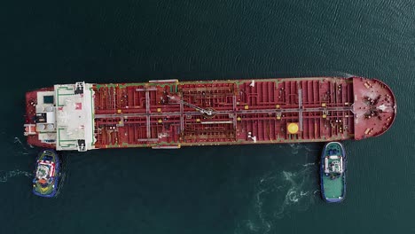 tug boats assisting a tanker in distress out on the open ocean - cenital, aerial view