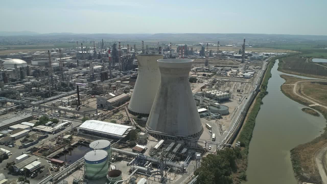 аэрофотосъемка крупномасштабного нефтеперерабатывающего завода с дымовыми трубами и резервуарами для хранения нефтепродуктов