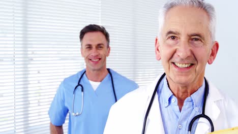portrait of male doctors and coworker standing with arms crossed