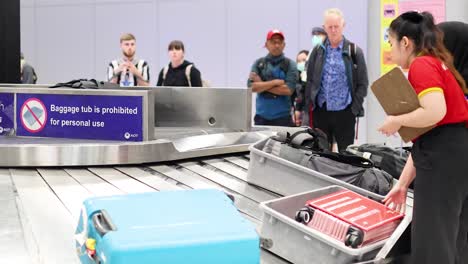 passengers retrieve luggage at baggage carousel