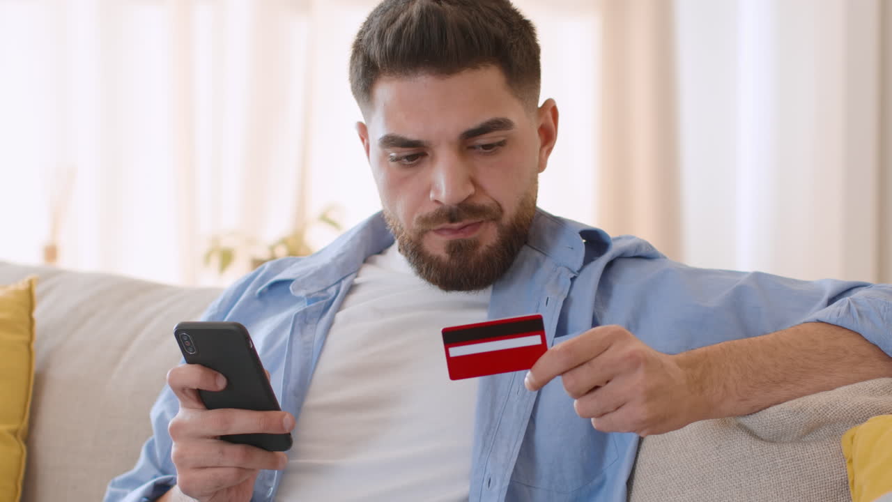 Man using a smartphone and holding a credit card for online shopping or banking